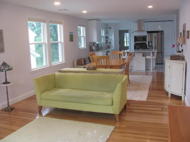 a living room with furniture a flat screen tv and kitchen view