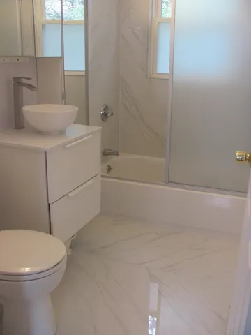 a bathroom with a sink a toilet and shower
