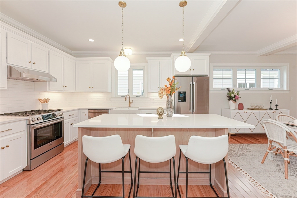 9 Damon Road, Unit 15 Needham Heights, MA 02494 - Photo 5 of 18 a kitchen with granite countertop a table chairs stove and white cabinets