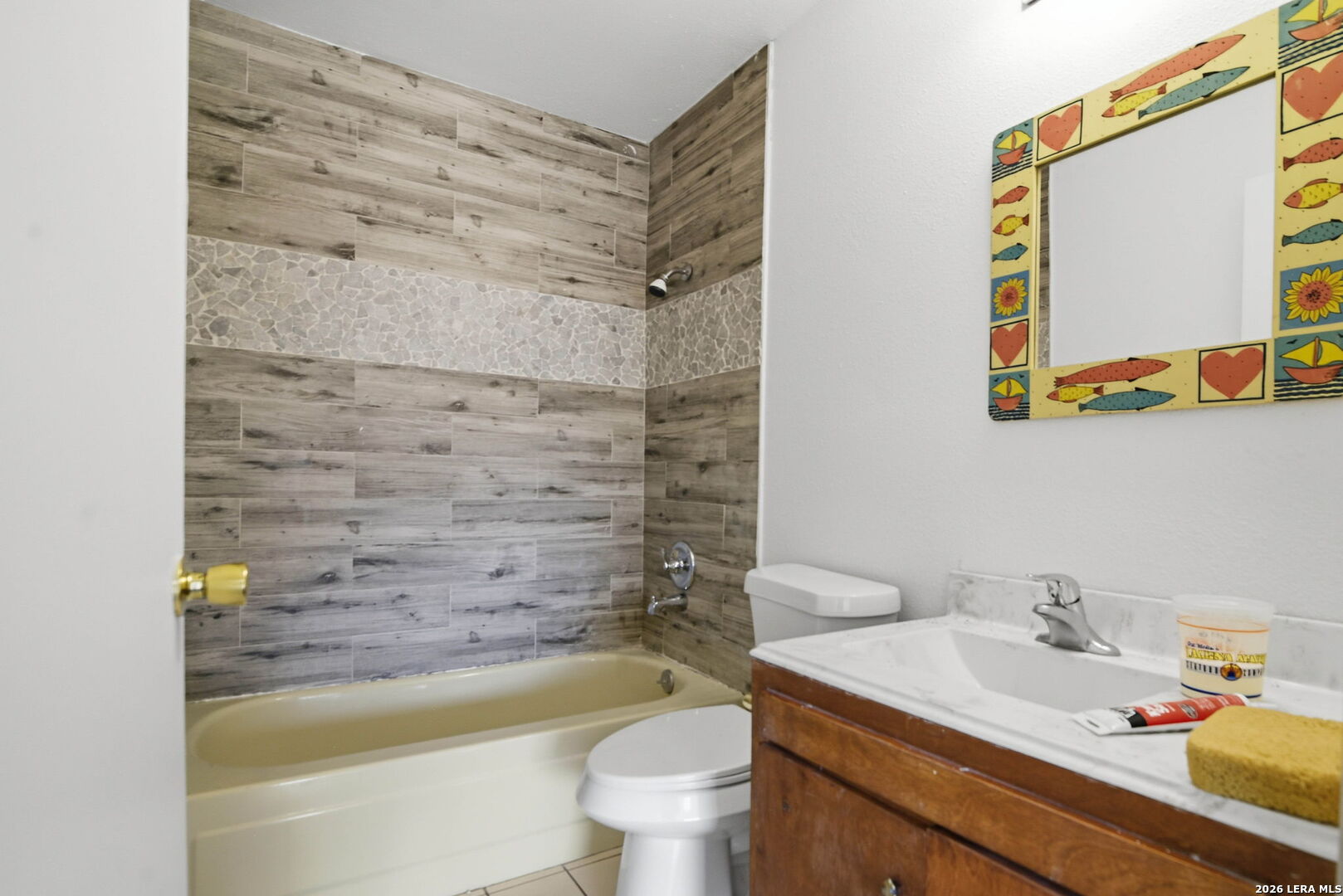 508 Crouch Avenue Devine, TX 78016 - Photo 20 of 26 a bathroom with a granite countertop sink a toilet and a bathtub