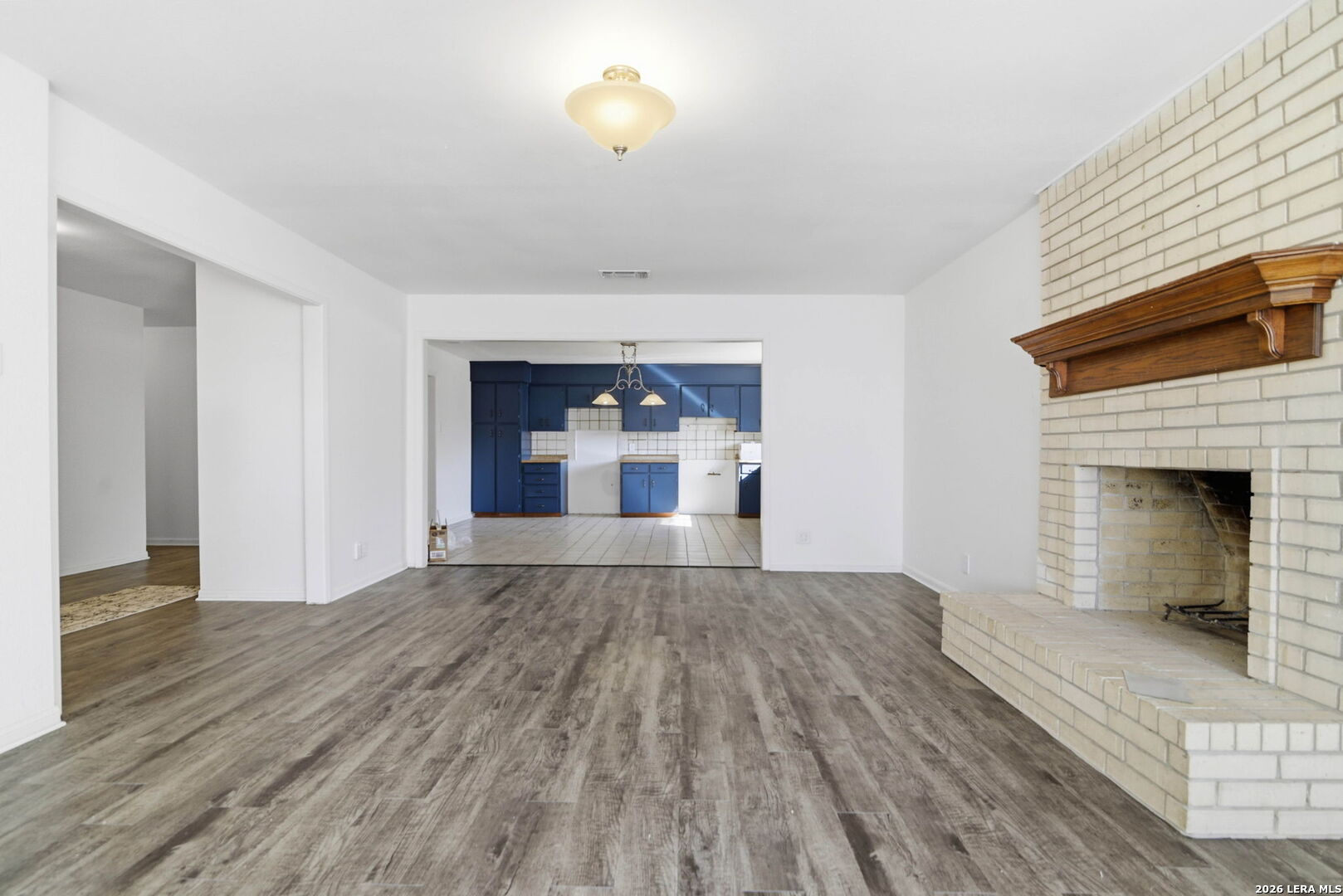 508 Crouch Avenue Devine, TX 78016 - Photo 6 of 26 a view of a livingroom with wooden floor and a fireplace