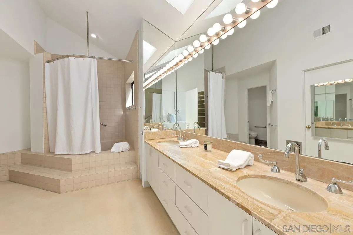 1888 Puente Drive La Jolla, CA 92037 - Photo 29 of 30 a spacious bathroom with a granite countertop sink a mirror and a shower