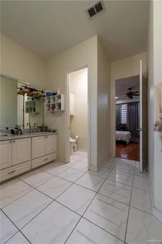 a view of a hallway and a bathroom with mirror