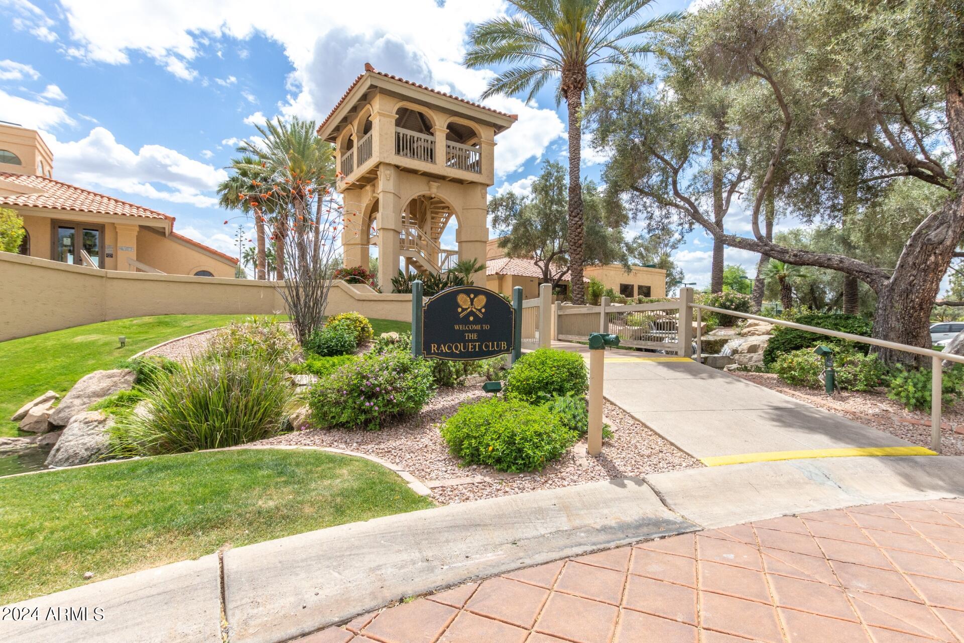 9705 East Mountain View Road, Unit 1036 Scottsdale, AZ 85258 - Photo 25 of 50 a front view of a house with a yard and potted plants