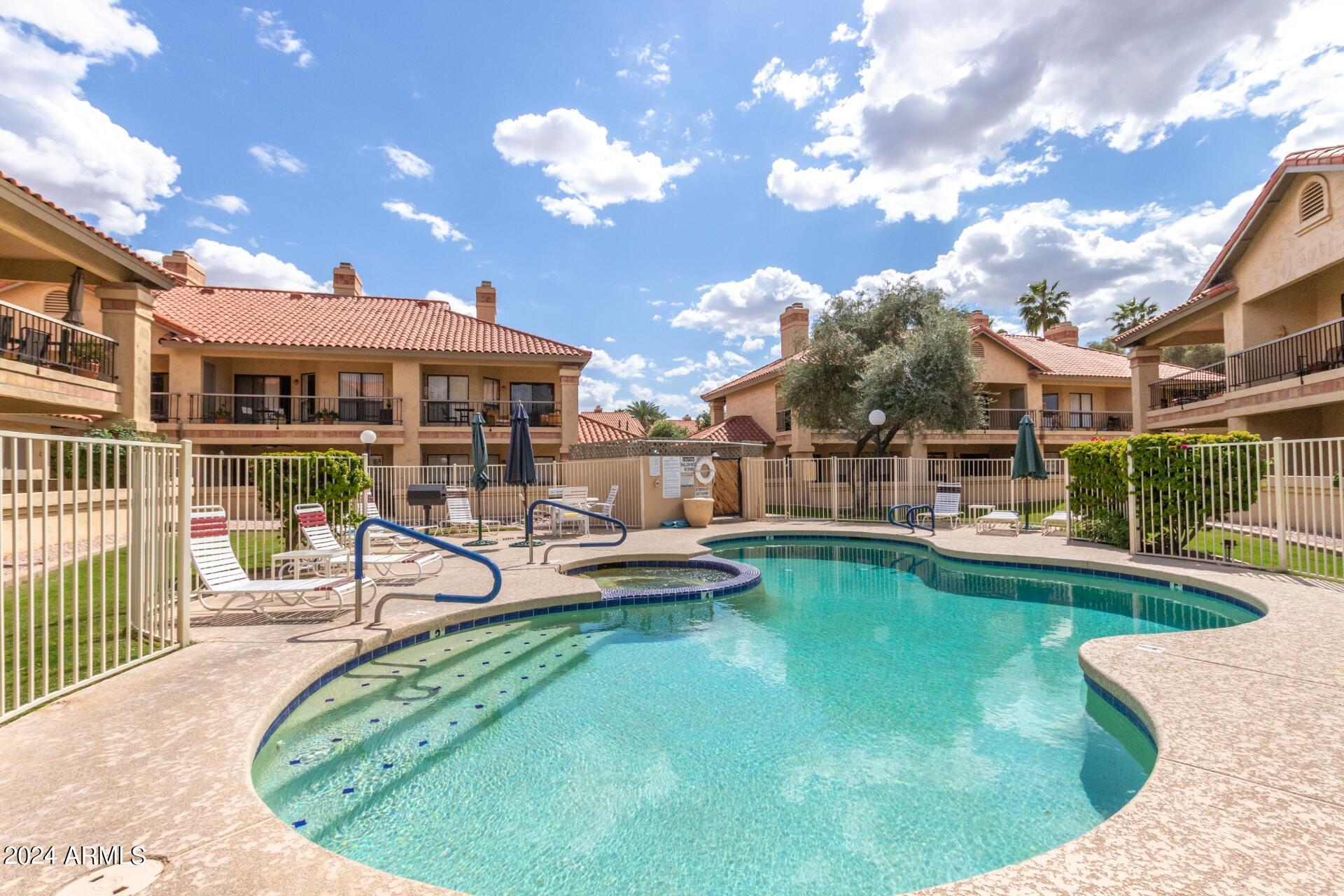 9705 East Mountain View Road, Unit 1036 Scottsdale, AZ 85258 - Photo 26 of 50 a view of a house with swimming pool and sitting area