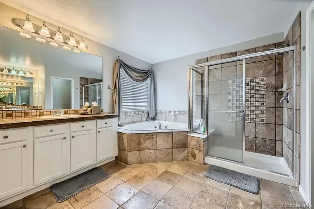 a spacious bathroom with a shower a mirror and a sink