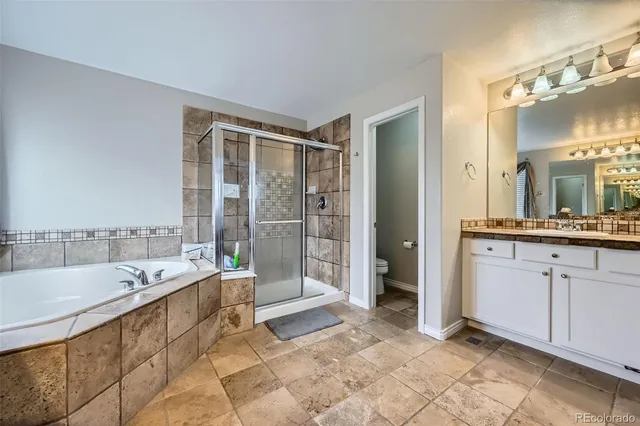 a spacious bathroom with a tub sink and mirror