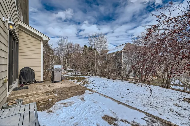 a view of a backyard with two chairs and a table
