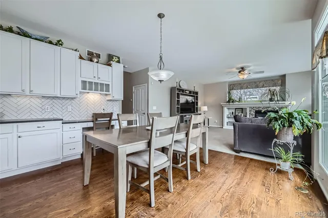a kitchen with stainless steel appliances kitchen island granite countertop a table chairs sink and cabinets