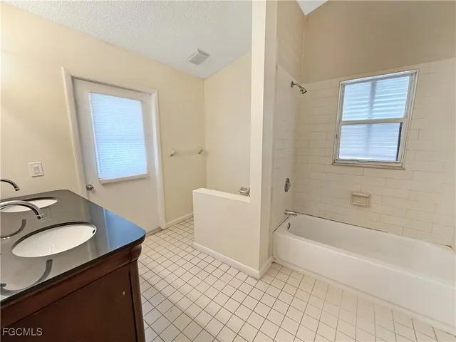 a spacious bathroom with a granite countertop sink a mirror and a toilet
