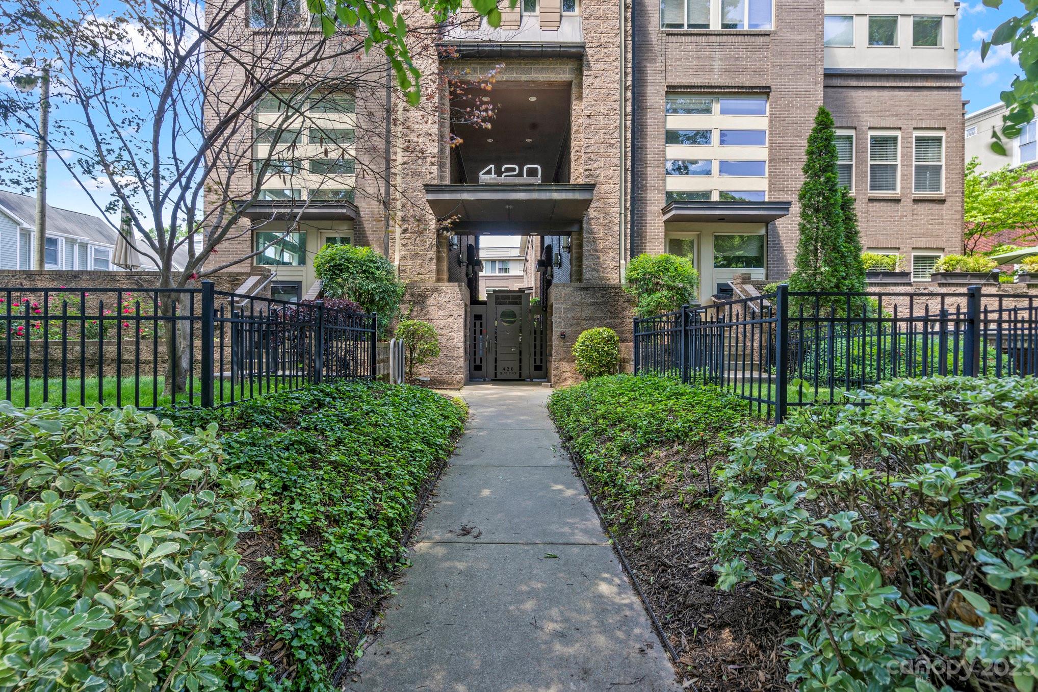 420 Queens Road, Unit 3 Charlotte, NC 28207 - Photo 26 of 35 a view of a brick house with a small yard and plants