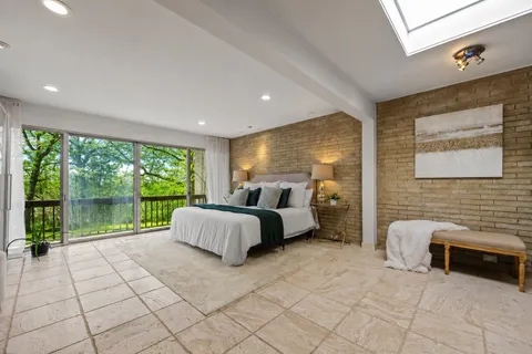 a spacious bedroom with a bed and a large window