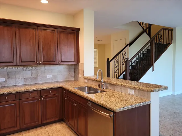 a kitchen with granite countertop a sink and cabinets