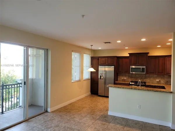 a kitchen with stainless steel appliances a refrigerator and a stove top oven