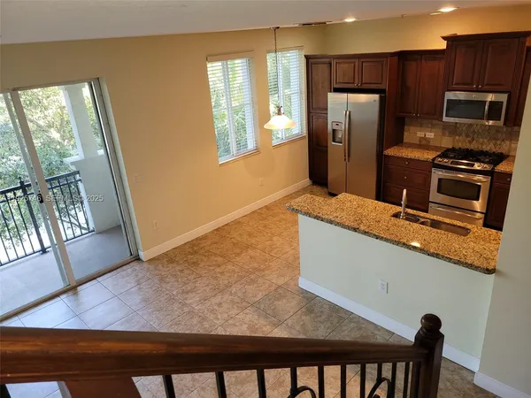 a kitchen with stainless steel appliances granite countertop a refrigerator and a stove