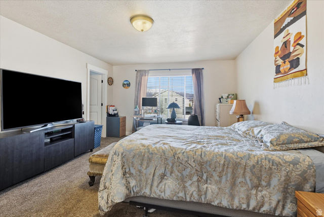 1084 South 740 East Logan, UT 84321 - Photo 8 of 23 Carpeted bedroom featuring a textured ceiling