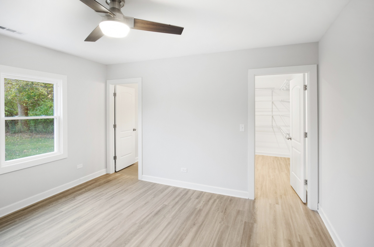 715 Anthony Trail Northbrook, IL 60062 - Photo 7 of 20 an empty room with wooden floor cabinet and windows