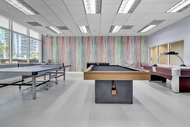 a living room with furniture a table and a pool table
