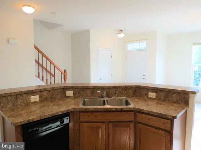 a kitchen with granite countertop a sink and cabinets