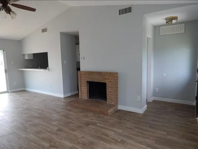 a view of a livingroom with wooden floor and a fireplace