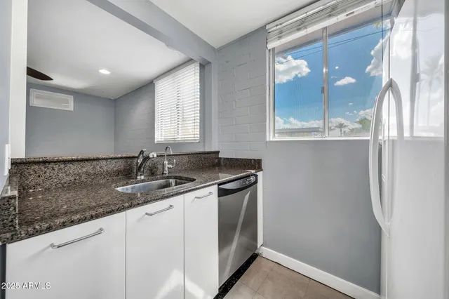 a bathroom with a granite countertop sink and mirror