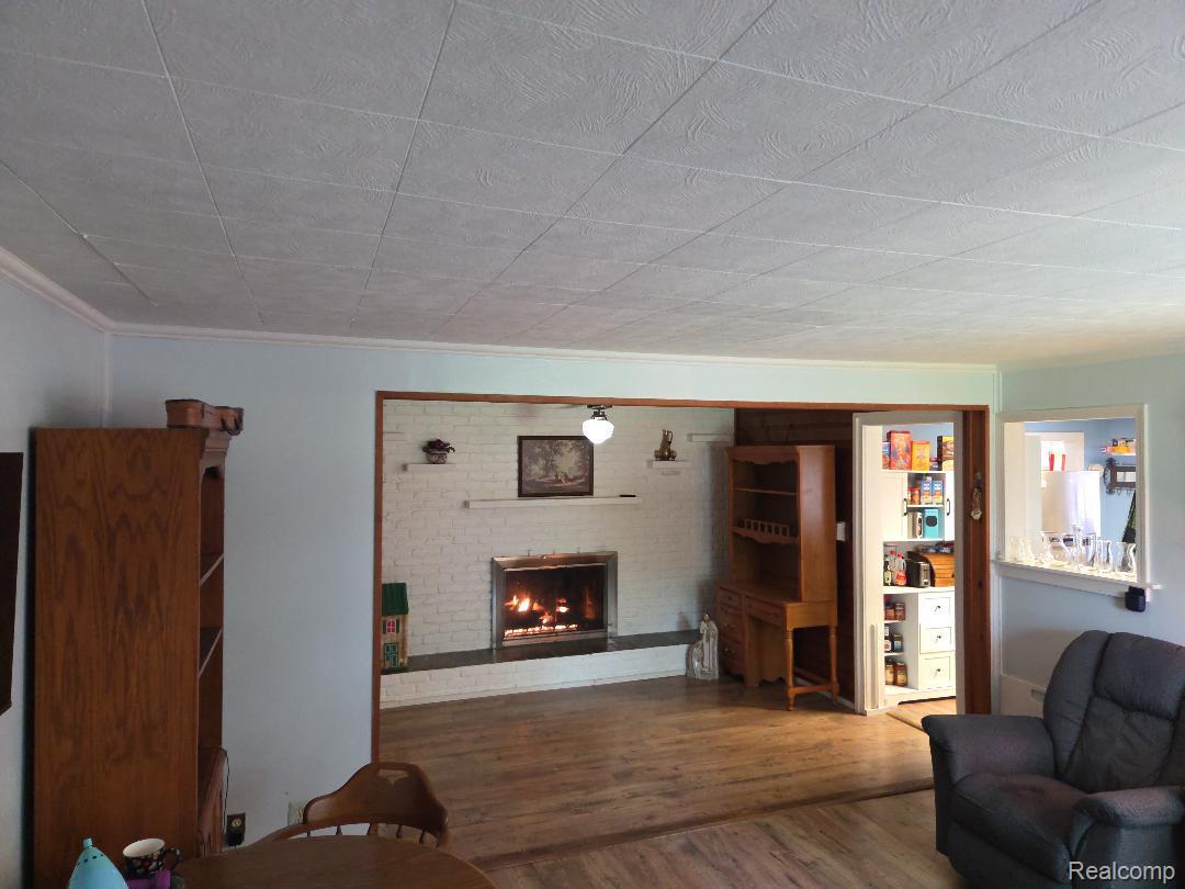 445 Clark Road Highland, MI 48357 - Photo 7 of 7 Living area featuring wood-finish flooring and crown molding