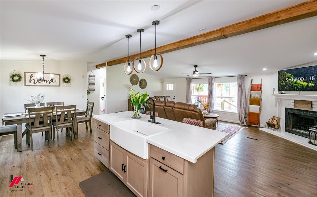 14631 Pecan Road Keithville, LA 71047 - Photo 40 of 40 a view of a dining room and livingroom with furniture wooden floor a rug a flat screen tv a painting and a chandelier