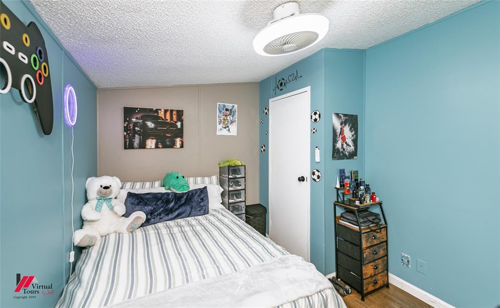 14631 Pecan Road Keithville, LA 71047 - Photo 21 of 40 a bedroom with a bed and a chandelier