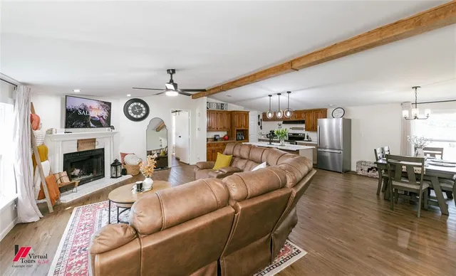 a living room with furniture kitchen view and a fireplace
