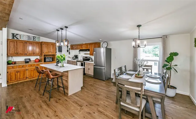 a kitchen with a table chairs refrigerator and microwave