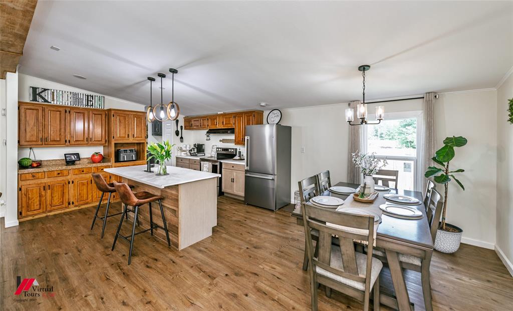 14631 Pecan Road Keithville, LA 71047 - Photo 10 of 40 a kitchen with a table chairs refrigerator and microwave