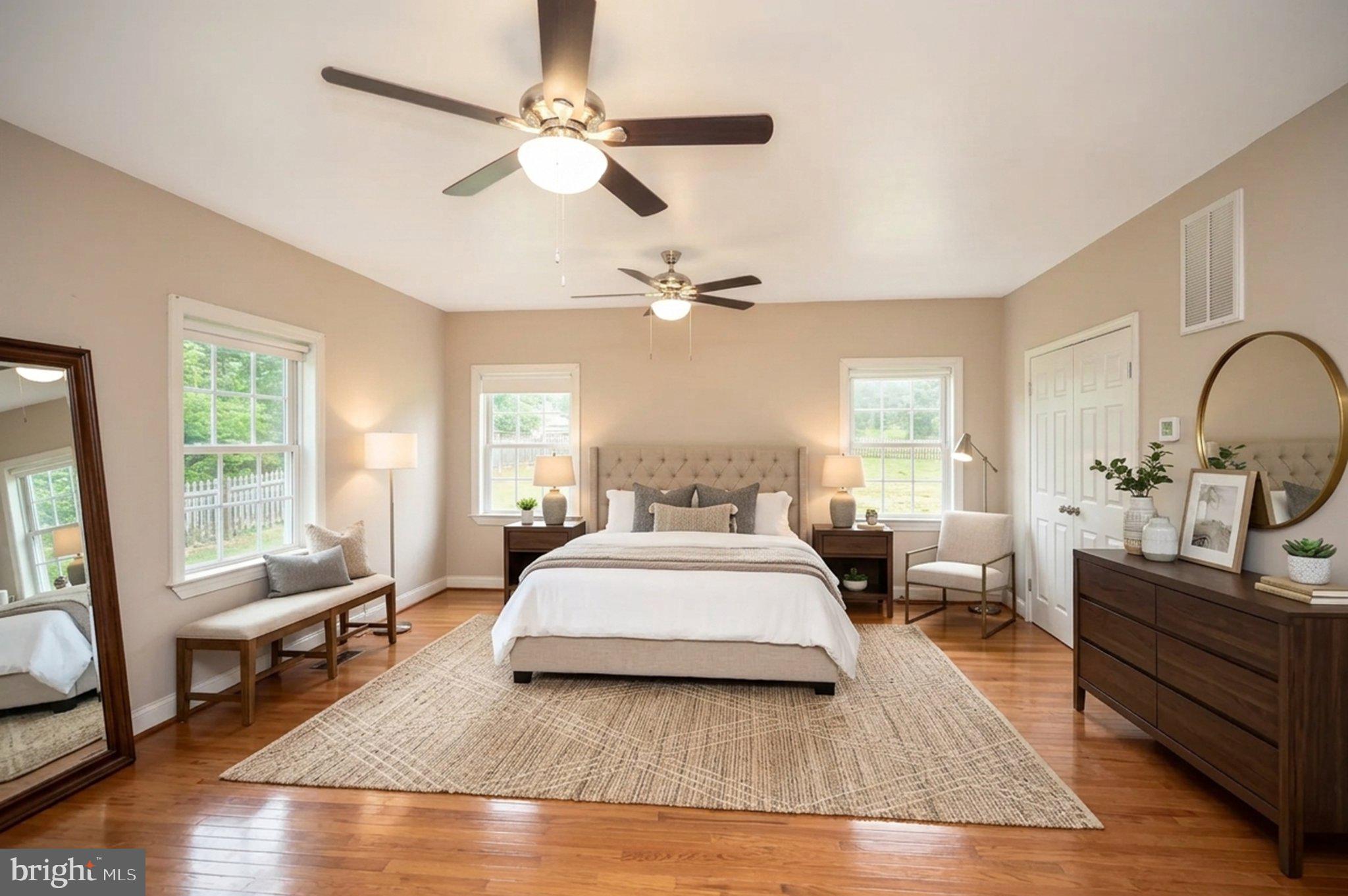 23202 Village Road Unionville, VA 22567 - Photo 6 of 58 a spacious bedroom with a large bed a chandelier and windows