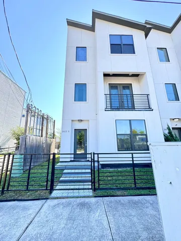 a view of a house with a small yard and wooden fence