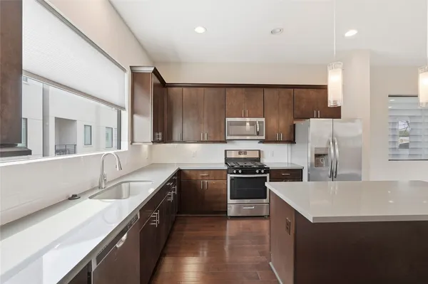 a kitchen with a refrigerator stove top oven and sink