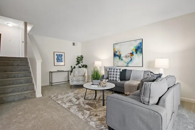 a living room with furniture and a painting on the wall