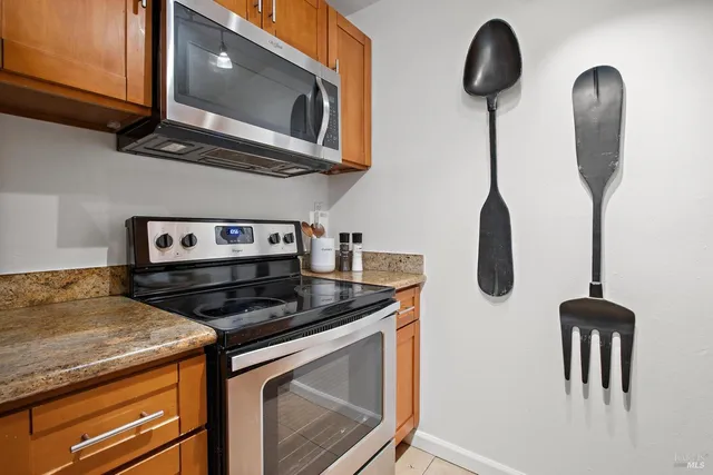 a kitchen with stainless steel appliances granite countertop a stove a microwave and cabinets