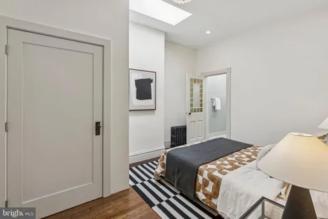 a bedroom with a bed and a lamp with the dresser