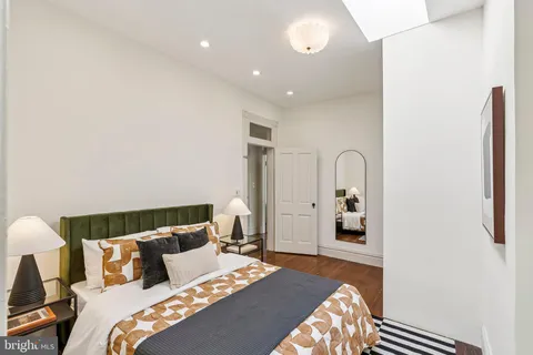 a bathroom with a sink a toilet a window and shower