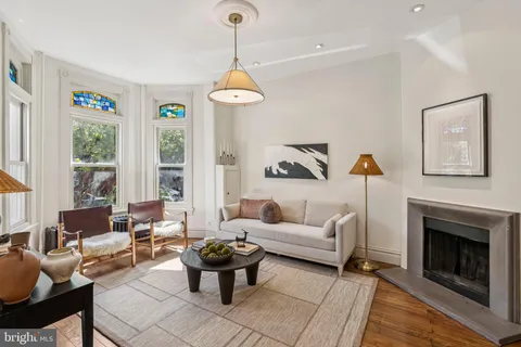 a living room with furniture a fireplace and a chandelier