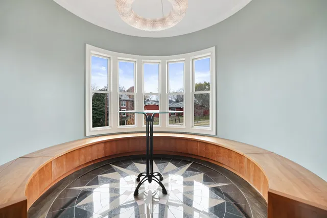 a view of a dining room and livingroom with furniture wooden floor a chandelier