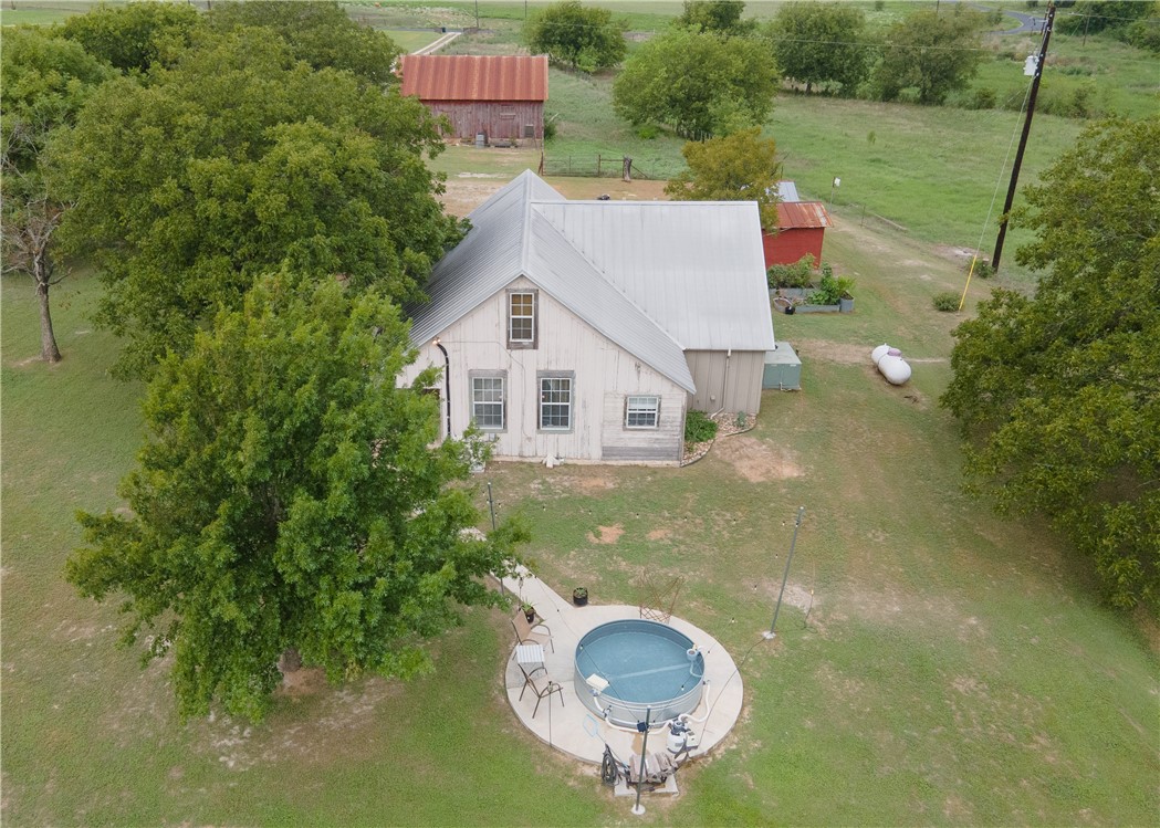 a aerial view of a house with swimming pool and green space