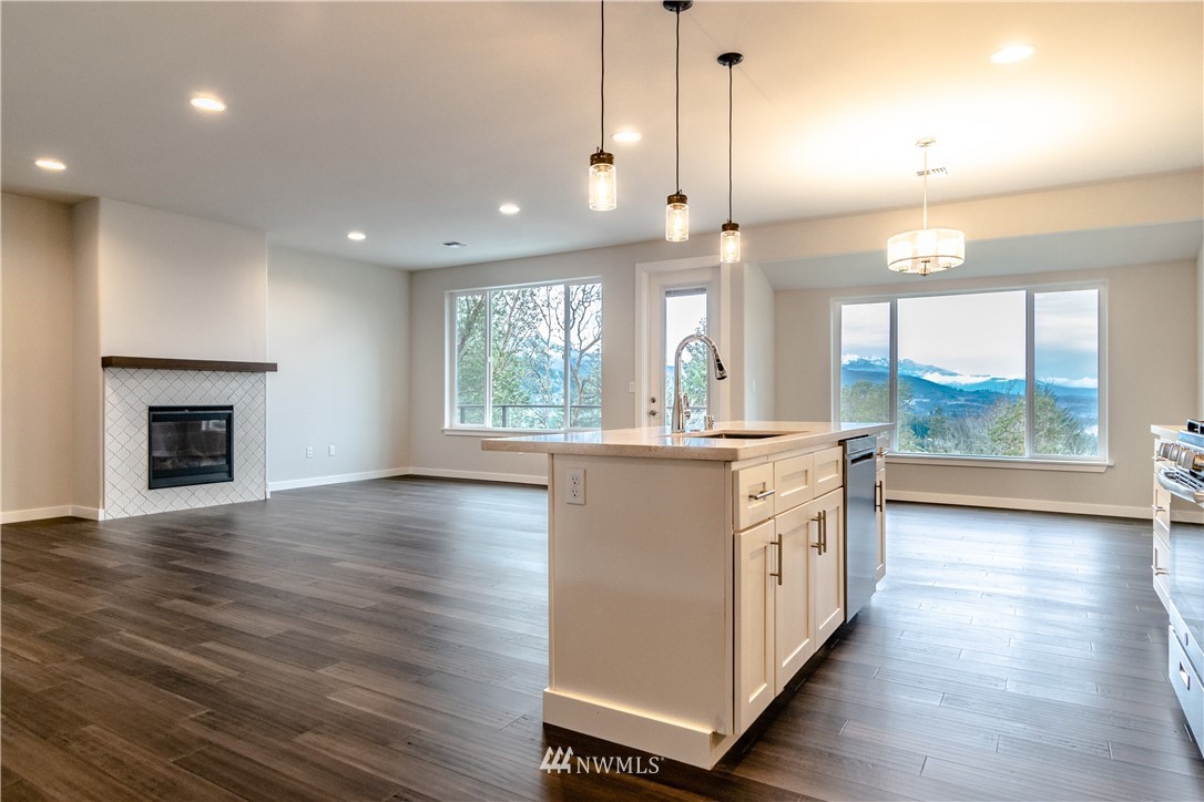 1710 Doe Run Road Sequim, WA 98382 - Photo 14 of 34 an empty room with wooden floor and a fireplace