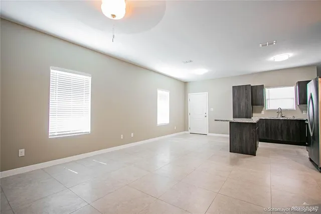 a view of an empty room with a kitchen