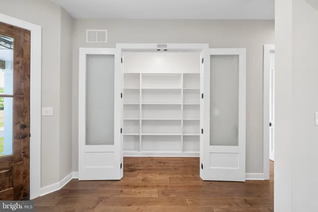 a view of an empty room with cabinet and door