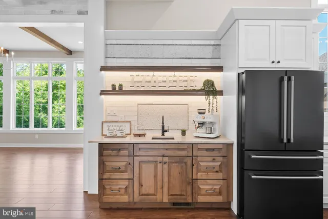 an open kitchen with wooden floor and stainless steel appliances