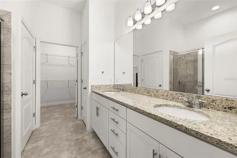 a bathroom with a granite countertop sink a toilet and a shower