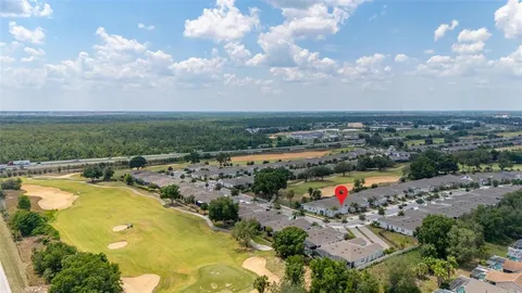 a living room with furniture floor to ceiling window and potted plants