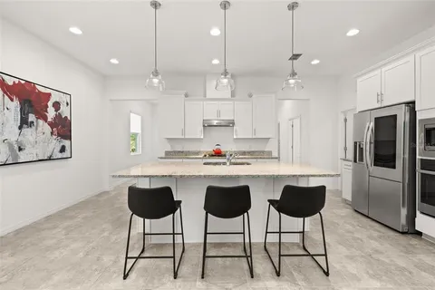 a kitchen with stainless steel appliances granite countertop sink stove and white cabinets