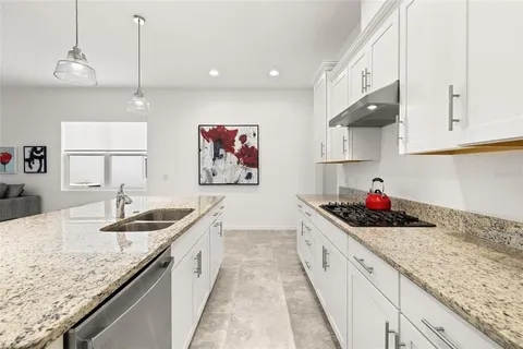 a kitchen with granite countertop a sink and cabinets