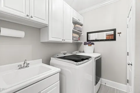 a utility room with sink dryer and washer